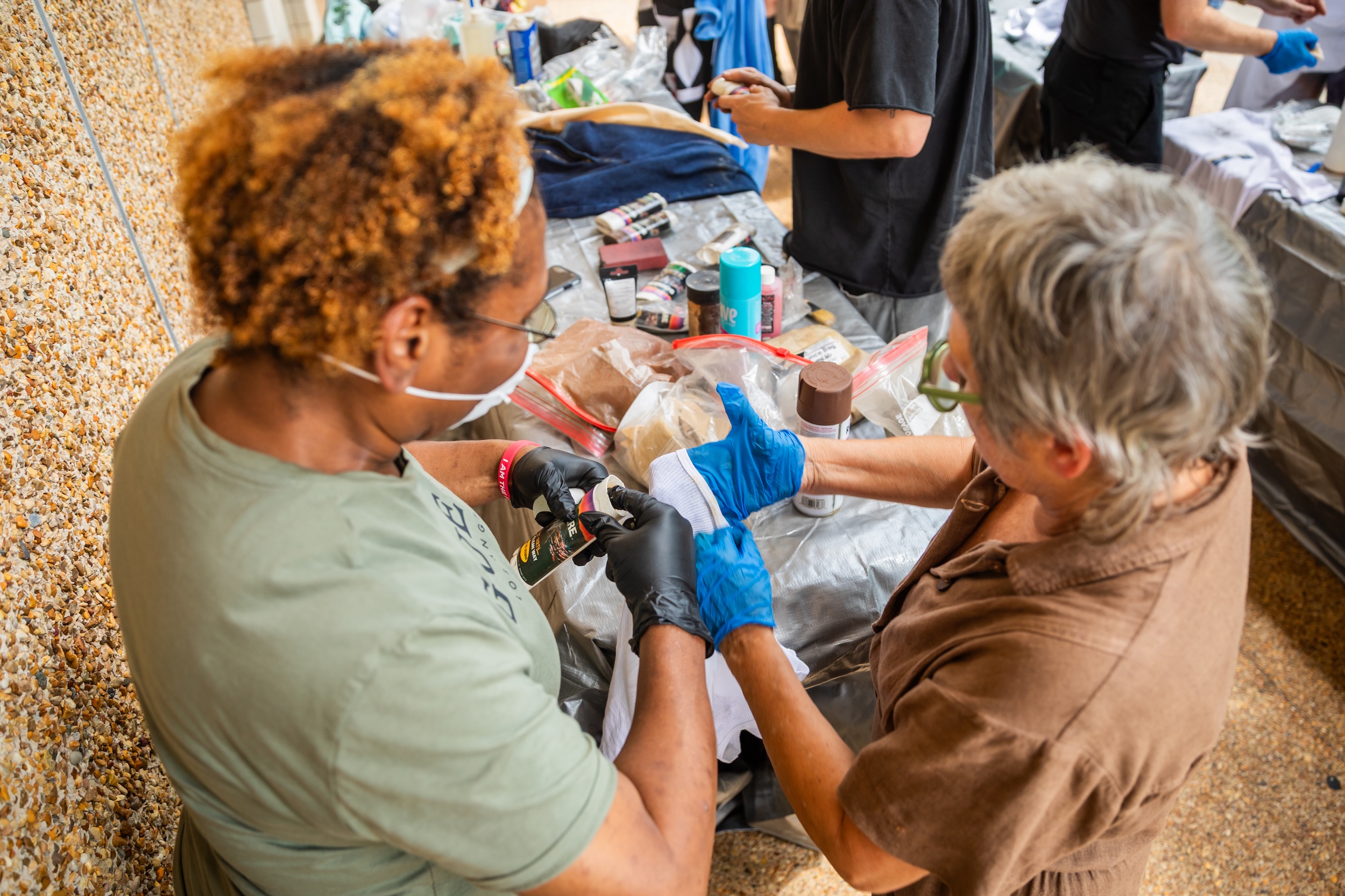 Costumers apply effects to clothing.